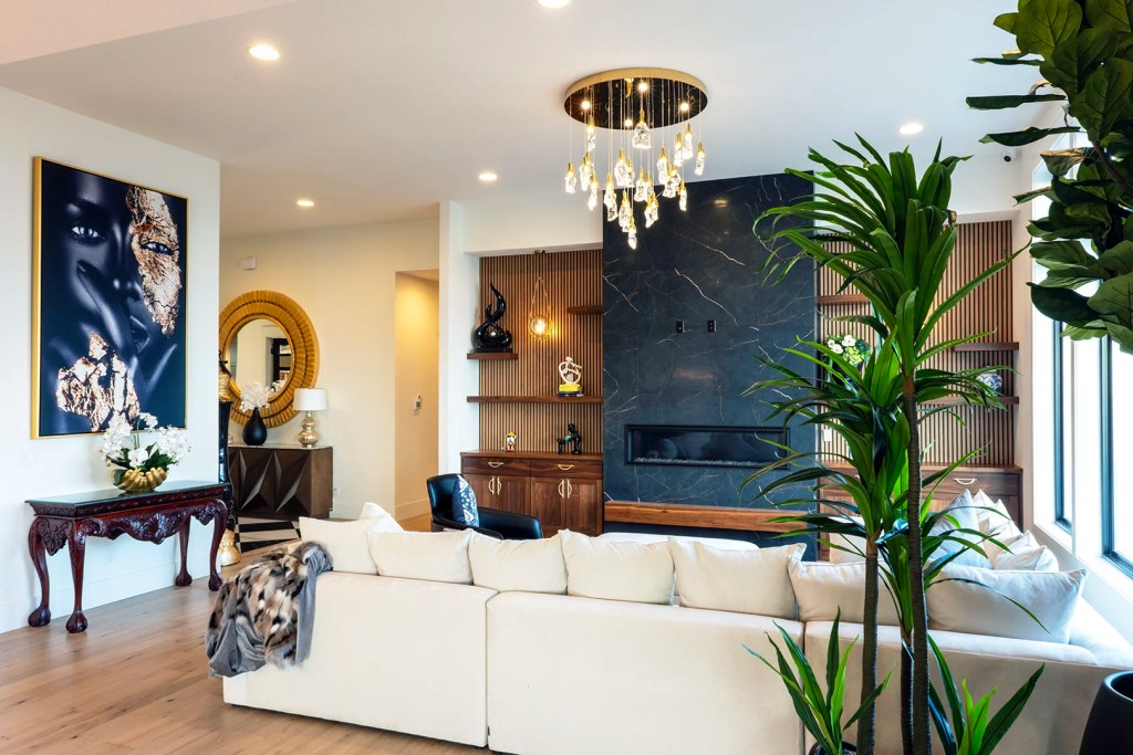 Modern living room remodel in Salem, Oregon with custom fireplace, wood built-ins, chandelier, and large windows.